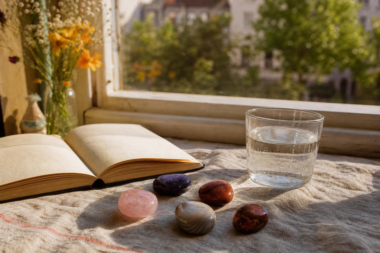 Polished tumble stones in warm colours resting on a linen cloth by a European window
