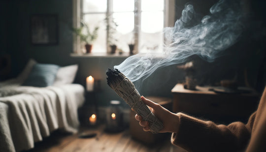 Bruciare un bastoncino di salvia bianca per la purificazione spirituale, con un delicato fumo di erbe che sale in una stanza calma e illuminata naturalmente