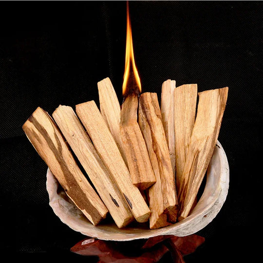 Humo de Palo Santo flotando por una habitación suavemente iluminada, evocando un espacio sereno para la meditación y la relajación