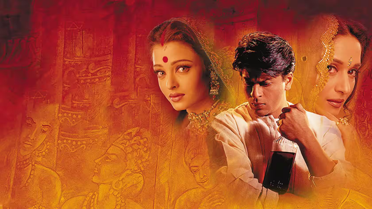 Ilustrovaný záber z filmu Devdas, zachytávajúci honosné prostredie bengálskej aristokracie a klasické tanečné vystúpenie kurtizány v sýtych červených a zlatých tónoch