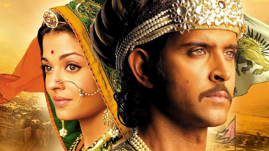 Ilustrovaný filmový záber z filmu Jodhaa Akbar zobrazujúci honosný kráľovský dvor z obdobia Mughalskej ríše, ktorý spája rádžpútske a mughalské zvyky a odevy