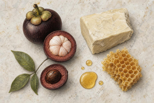 Ingredientes naturales sin procesar para un bálsamo, semilla de kokum, manteca de karité, cera de abeja y aceite portador, dispuestos sobre piedra clara