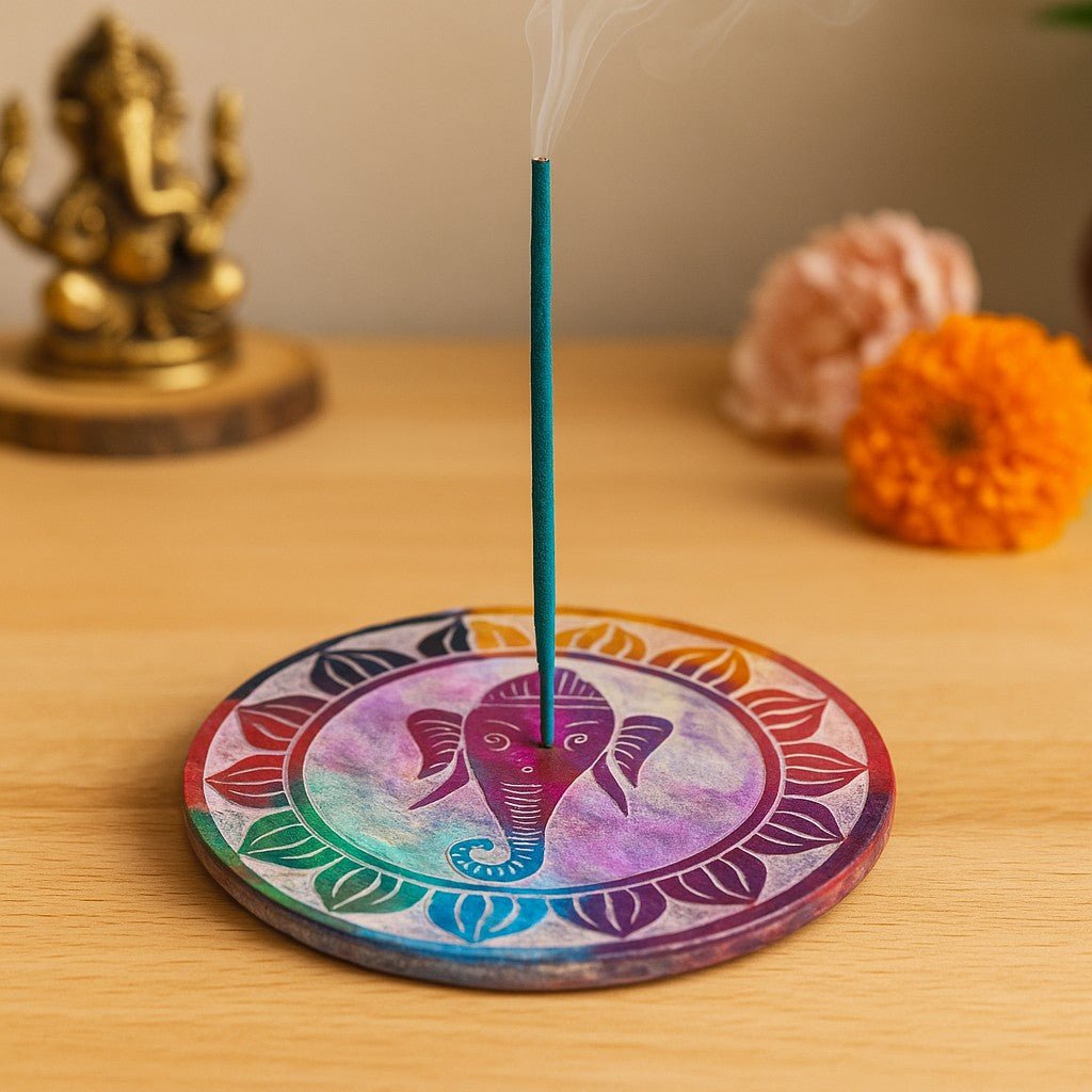 Incense stick on a colorful circular holder with a statue and flowers in the background