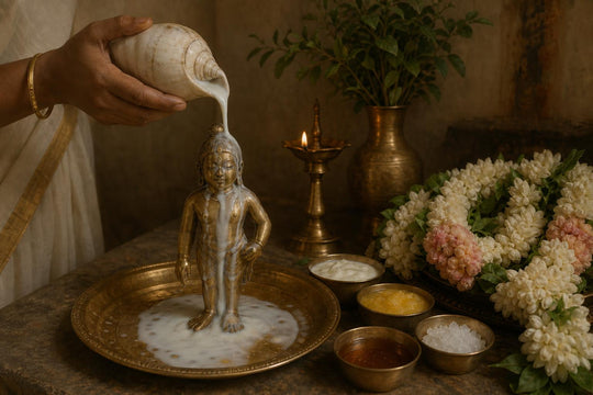 Una murti de bronce bañada en leche vertida desde una caracola, con cuencos de los cinco néctares a su lado bajo la luz de las lámparas.