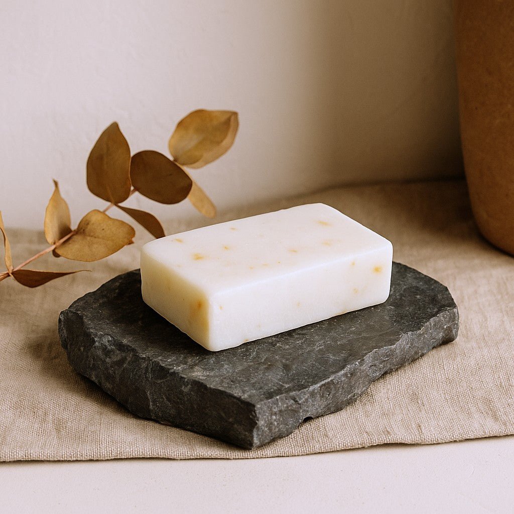 Bar of soap on a dark stone surface with a beige background