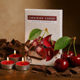 Chocolate cherry scented tealights with packaging and cherries on a wooden surface