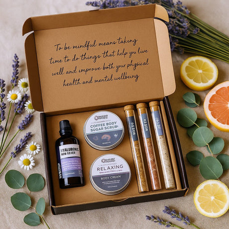 Box of natural body care products with lavender, lemon, and orange on a textured surface.