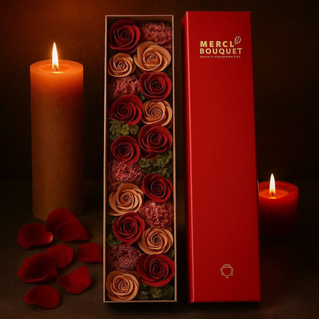 Box of roses with a lit candle and 'Merci Bouquet' branding on a dark background