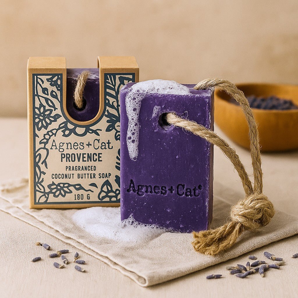 Purple soap bar with a rope, Agnes & Cat branding, on a beige cloth with lavender flowers.