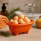Orange bath tub-shaped container with bath bombs on a bathroom counter.