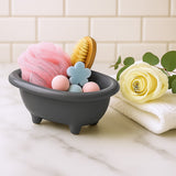 Gray bath toy organizer with various bath items on a marble surface with a tiled wall background.
