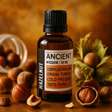 Bottle of Ancient Wisdom hazelnut oil with hazelnuts on a wooden surface