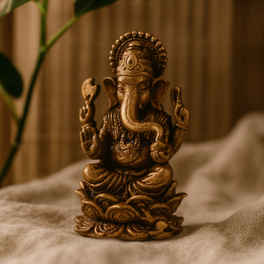Lille antik Ganesha-statue af messing på en lotus, oplyst af stearinlys