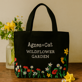 Bolsa de mano con diseño de setas bordada en negro
