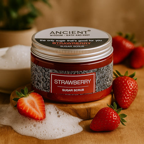 Jar of strawberry sugar scrub with strawberries around on a wooden surface