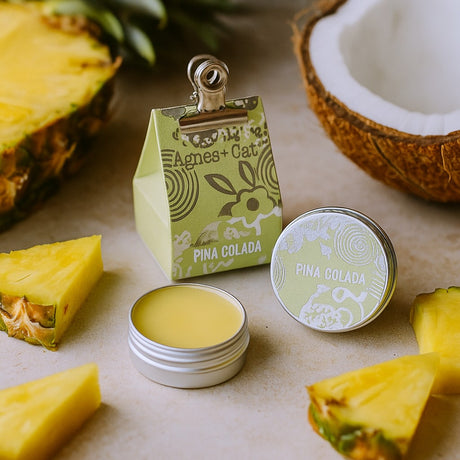 Pina Colada themed product with pineapple slices and a coconut on a neutral background