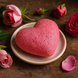 Heart-shaped pink soap on a plate with roses and petals on a wooden surface