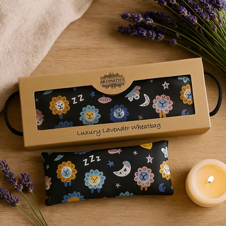 Luxury lavender wheatbag with floral design in a box on a wooden surface with lavender and a candle.