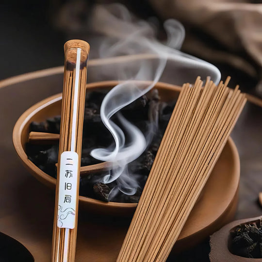 Bundle of natural Chinese incense sticks resting in a holder, thin smoke rising