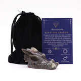 Gemstone dragon figurine with a black drawstring bag and information card on a white background