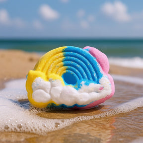 Colorful cloud-shaped object on a beach with ocean waves.