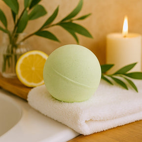 Green bath bomb on a white towel with a candle and lemon in the background