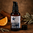 Beard oil bottle with star label on a wooden surface with orange and cinnamon sticks.