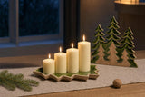 Four Sundays: A modern Advent wreath without the fir: four ivory pillar candles of graduated heights in a green-enamel tree tray, with three carved mango-wood evergreens