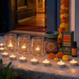 Lights by the Door: Diwali candles for the step, the sill and the door: three pressed-flower glass holders, 12 vanilla tealights, and marigold oil in a carved soapstone burner