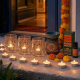 Lights by the Door: Diwali candles for the step, the sill and the door: three pressed-flower glass holders, 12 vanilla tealights, and marigold oil in a carved soapstone burner