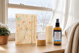 The First Page: A New Year gift: a handmade lokta journal, a clear quartz sphere, an ivory pillar candle and a lemon and pine room spray