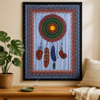 Decorative wall tapestry with a colorful circular design and feathers on a wooden table.