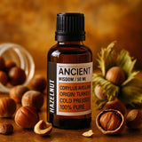 Bottle of Ancient Wisdom hazelnut oil with hazelnuts on a wooden surface
