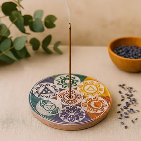 Incense burner with geometric designs on a beige surface with plants and seeds.