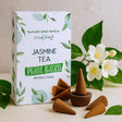 Jasmine tea incense cones with packaging and plants on a light background