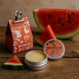 Watermelon-flavored product packaging with watermelon slices on a wooden surface