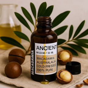 Bottle of macadamia oil with a label on a beige cloth with macadamia nuts.
