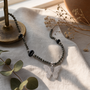 Nymph Black Obsidian Gemstone Necklace with Real Leaf Butterfly Pendant — styled in a warm, naturally lit interior