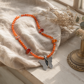 Nymph Ruby Gemstone Necklace with Real Leaf Butterfly Pendant — styled in a warm, naturally lit interior