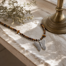 Nymph Tiger's Eye Gemstone Necklace with Real Leaf Butterfly Pendant — styled in a warm, naturally lit interior