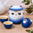 Tea set with panda-shaped teapot and cups on a wooden surface