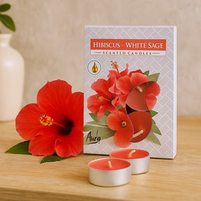 Hibiscus and White Sage scented candles with packaging on a wooden surface