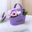 Purple flower-shaped soap basket with flowers on a white surface