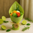 Bouquet of flowers wrapped in green paper with limes and leaves on a beige background