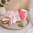 Pink flower bouquet with a bow on a beige plate