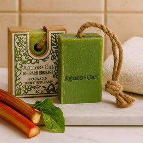 Green soap bar with rope and packaging labeled 'Agnes + Cat' on a bathroom counter.