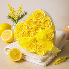 Heart-shaped box of yellow roses with lemons and towels on a light background