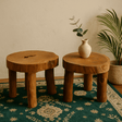 Two wooden stools with a vase on a patterned rug