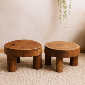 Two wooden stools on a textured floor with a neutral wall background