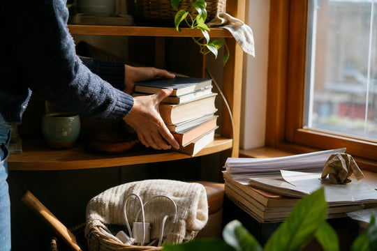A hand clearing clutter from a corner of a European room as part of tidying the space